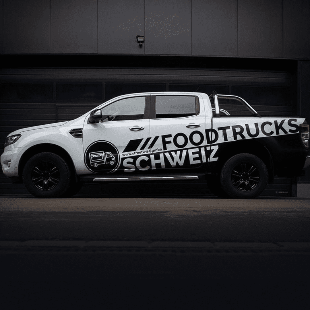 Weißer Lieferwagen mit "FoodTrucks Schweiz" Beschriftung.